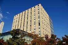 Square, light-colored building against a blue sky