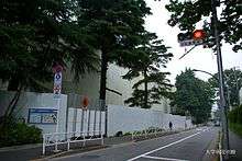 Side of white building and trees from street