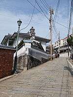 Slope, stone walls and a wooden house.