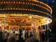 Church choir sing at fair. A merry-go-round fills most of the background.