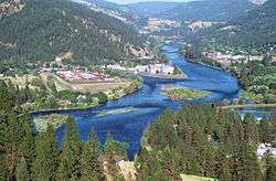 An aerial view of a large river flowing through forested hills