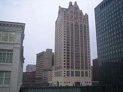 100 East Wisconsin rises tall with several other buildings visible along the river.