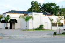 Photo of a white low-rise building and parking lot.