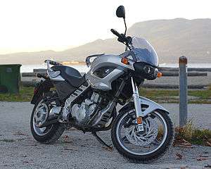 Silver BMW F650CS parked on brick paving