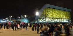 Night view of modern building, with many people walking outside