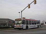 A white bus passes through an intersection.