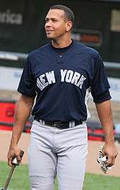 Alex Rodriguez, standing center, in a New York Yankees uniform. Rodriguez is holding batting gloves in his left hand and a metal rod-shaped object in his right.