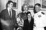 Young man, middle-aged woman, young boy, middle-aged man, all in formal attire