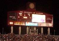 Large scoreboard above the stands of an American football stadium.