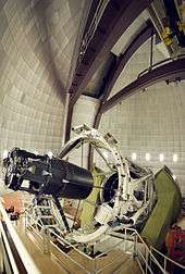 A complex piece of cylindrical machinery rising several metres above the floor of a large enclosing dome