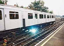 Spark coming from beneath electric passenger train