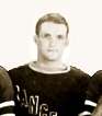 Upper body of a young man with short hair and a serious look. He is wearing a hockey sweater with part of the word "RANGERS" visible in a diagonal pattern from his right chest down to the left.