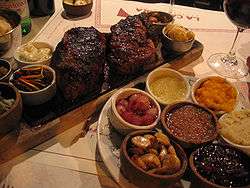 Table with a cut of Argentine beef, wine, sauces and spices