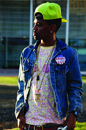 Side profile of a man wearing a denim jacket and a cap