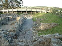 The ruins of a building.  The remains of stone walls up to about 1-foot (0.3m) are all that remains.