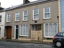 Photograph of a modest two story house.