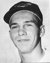 A smiling young man wearing a black baseball cap imprinted with a picture of a bird