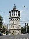 Ground-level view a tower with a circular cross section and a tapering spire