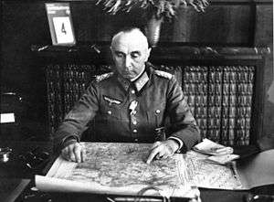 Paul Bader seated at desk looking at a map