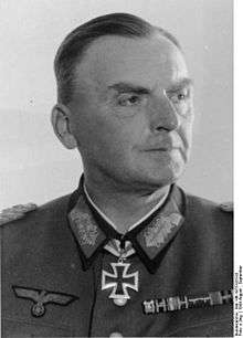 A man wearing a military uniform with an Iron Cross displayed at the front of his uniform collar.