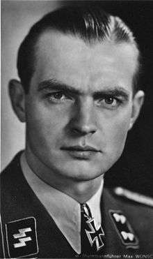 A man wearing a military uniform with an Iron Cross displayed at the front of his uniform collar.