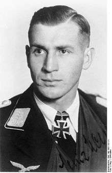 A man wearing a military uniform with an Iron Cross displayed at the front of his uniform collar.