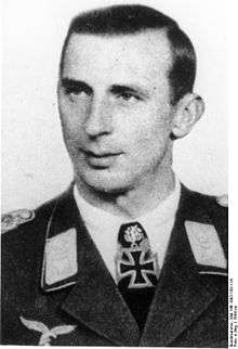 A man wearing a military uniform with an Iron Cross displayed at the front of his uniform collar.