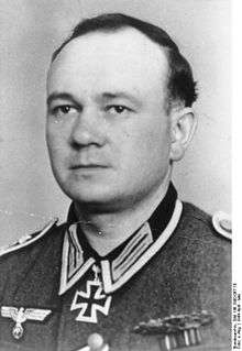 A man wearing a military uniform with an Iron Cross displayed at the front of his uniform collar.