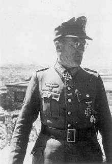 A man wearing a military uniform with an Iron Cross displayed at the front of his uniform collar.