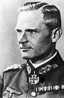 A man wearing a military uniform with an Iron Cross displayed at the front of his uniform collar.