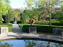 Ornamental garden with stone blocks with incised lettering around the edge of a pond