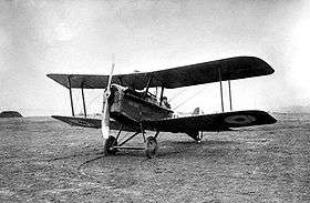 Three-quarter view of military biplane on landing ground