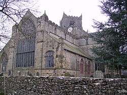 A complex stone church with a large west window and a central tower