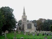 A stone church seen from the east, with a Perpendicular east window, and the end of the south aisle, the tower and spire visible beyond