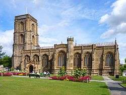 Stone building with arched windows and square tower.