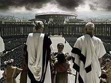 Men in white robes with the Colosseum in the background.