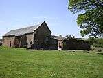 Long red brick building with grey roof.