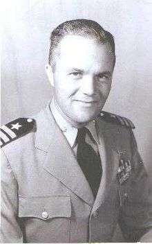 portrait photograph of a man wearing the uniform of an officer of the United States Navy, with the rank of commander.