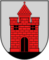 A coat of arms depicting a red castle with black double doors, two black windows, and one central tower all standing on black ground