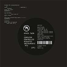 A grey background featuring white monospace text in the upper-left corner and a black circle slightly off centre to the right. Inside the circle a white logo is visible and "Aphex Twin - - Computer Controlled Acoustic Instruments pt2" is written in a block white monospace typeface; to the right of the white text, a barcode is visible as well as other miscellaneous text.