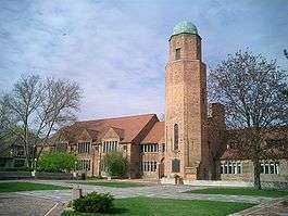 alt=A large brick building with a central tower