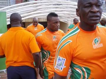 A close up shot of the Ivory Coast players, in their country's orange jerseys, entering the field from the dressing room tunnel.