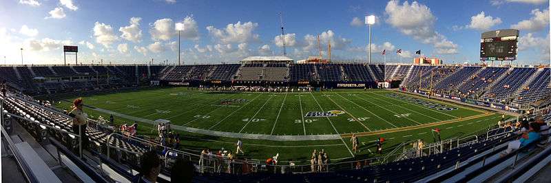 A wide photograph of a mostly empty stadium.