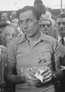 A black and white photo of a man in front of a crowd of people.