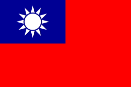 A red flag, with a small blue rectangle in the top left hand corner on which sits a white sun composed of a circle surrounded by 12 rays.