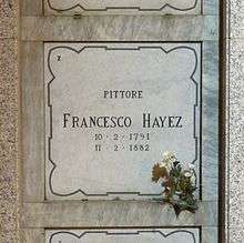 A marble gravestone on the wall of a crypt