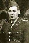 Image of a man in his military dress uniform with a soft hat. The image shows from the waist up