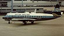 An aircraft pictured standing on the apron at an airport