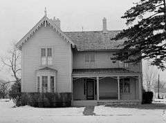 wooden slatted building, face-on, in snow