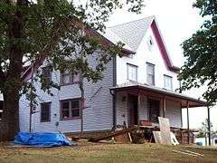 Photograph of a house undergoing exterior maintenance work